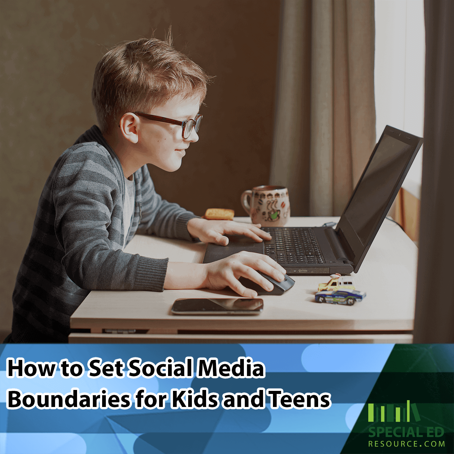 A young boy with glasses focused on using a laptop at a desk, with a mug and smartphone nearby, using the social media boundaries for kids his parents established from the tips in this blog post by /